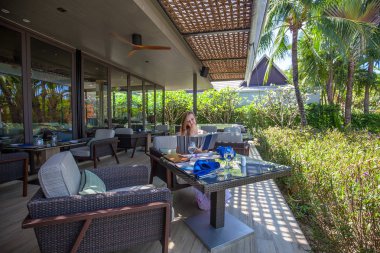 Menü açık restoranda oturan genç kadınla