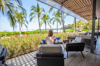 Menü açık restoranda oturan genç kadınla