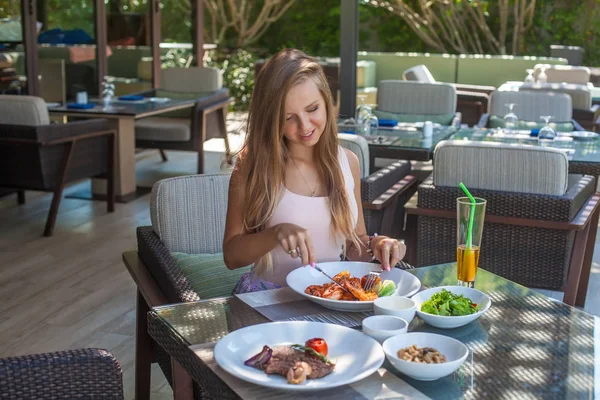 Mujer joven sentada en un restaurante tropical al aire libre — Foto de Stock