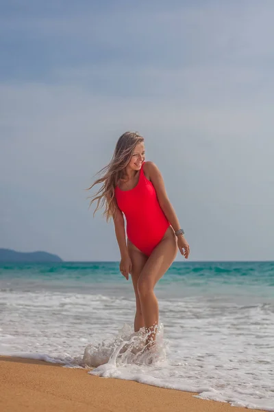 Sexy kobieta w czerwony strój kąpielowy na plaży — Zdjęcie stockowe