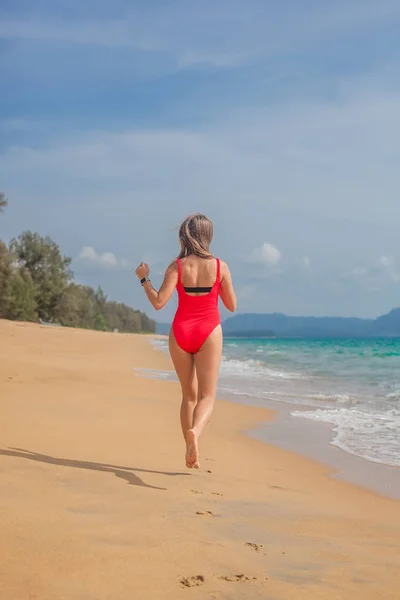 Sexy kobieta w czerwony strój kąpielowy na plaży — Zdjęcie stockowe