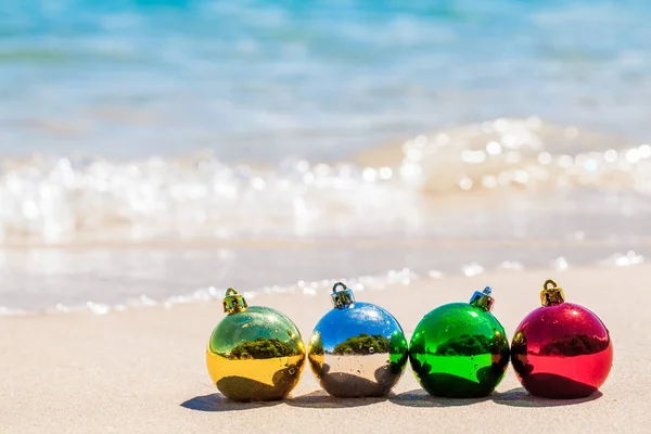 Четыре Рождественских Разноцветных Шара Берегу Моря Белым Песком Голубой Водой — стоковое фото
