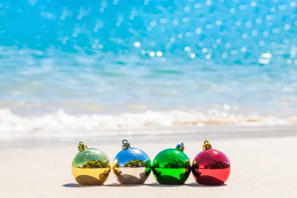 Four Christmas Multicolored Decoration Balls Seacoast White Sand Blue Water — Stock Photo, Image