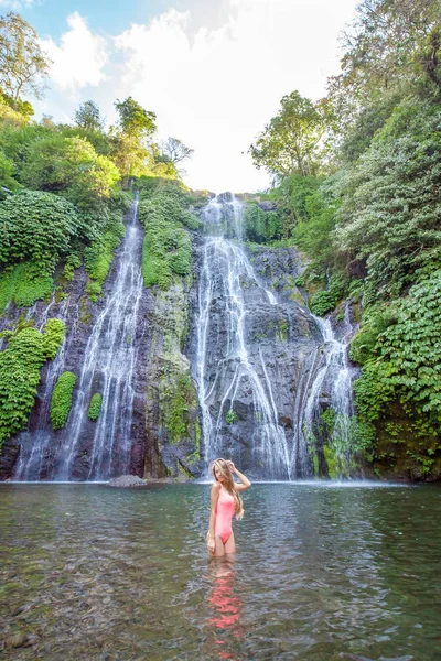 Young sexy woman in swimsuit in front of Banyumala twin waterfalls on Bali — Stock Photo, Image