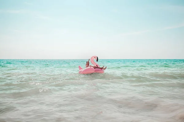 Man is plezier op roze flamingo opblaasbaar zwembad float — Stockfoto