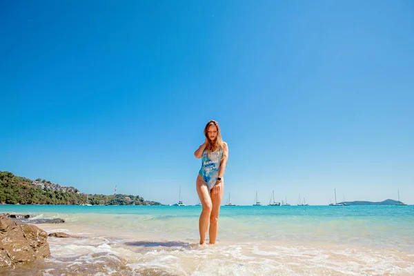 Mujer en traje de baño azul de pie en el mar — Foto de Stock