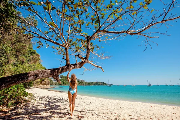 맑은 물과 해변에서 나무 근처에 서 있는 여자 — 스톡 사진