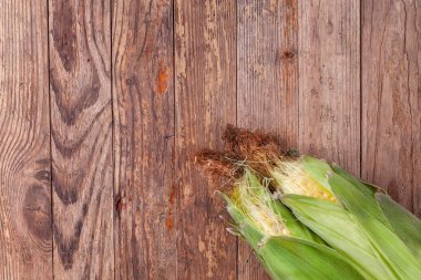 Ahşap masa üzerinde taze tatlı mısır çifti