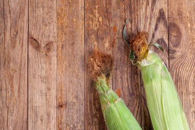 Ahşap masa üzerinde taze tatlı mısır çifti