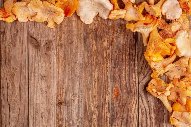 Ahşap arka plan üzerinde chanterelles çerçeve