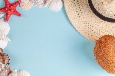 Hindistan cevizi, denizyıldızı, kabukları, mavi arka plan üzerinde hasır şapka