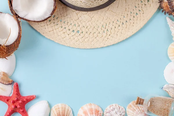 Flat lay composition with beautiful starfishes, sea shells, coconut, bottle with sand and straw hat on a blue background — Stock Photo, Image