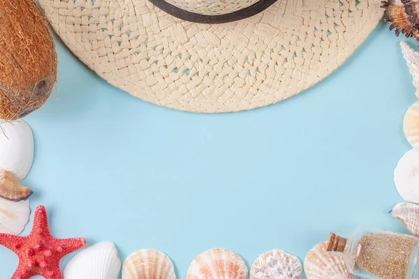 Platte lay samenstelling met mooie starvissen, zeeschelpen, kokosnoot, fles met zand en stro hoed op een blauwe achtergrond — Stockfoto