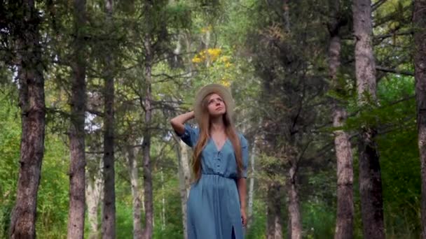 Joven hermosa mujer caminando por un sendero en un bosque de pinos — Vídeos de Stock