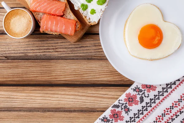 Café da manhã: ovo frito em forma de coração, sanduíche de salmão e café expresso — Fotografia de Stock