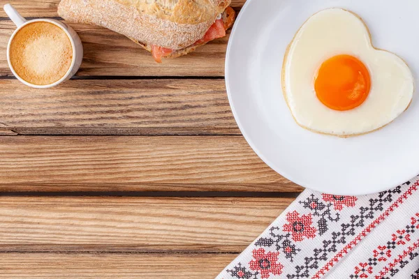 Café da manhã: ovo frito em forma de coração, sanduíche e xícara de café — Fotografia de Stock