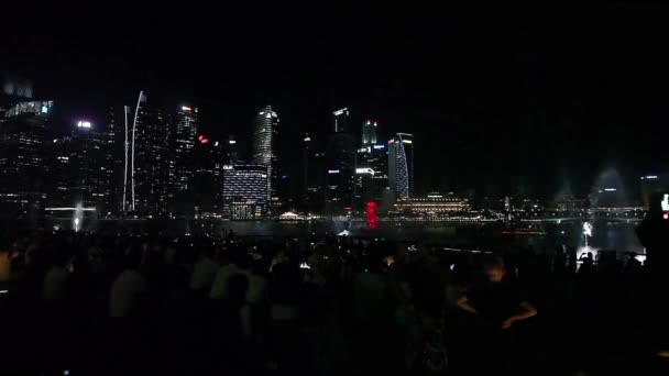 Avondlicht en laser Waterfontein show in de buurt van Marina Bay Sands in Singapore — Stockvideo