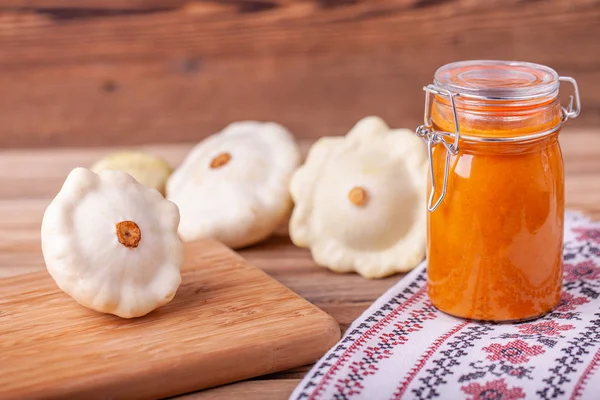 Squash caviar in a jar on the table on wooden table with white squash