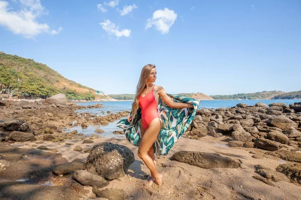 Sexy jonge vrouw met lang haar in rode badmode met gekleurde Beachwear op het strand — Stockfoto