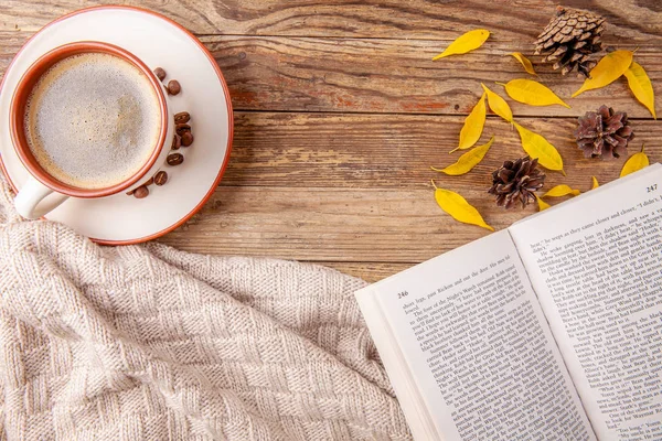 Tasse warmen Kaffee mit aufgeschlagenem Buch auf hölzernem Hintergrund. Herbstkonzept. — Stockfoto