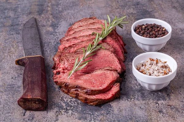 Slices of roast beef with rosemary, salt snd pepper on grey marble background — Stock Photo, Image