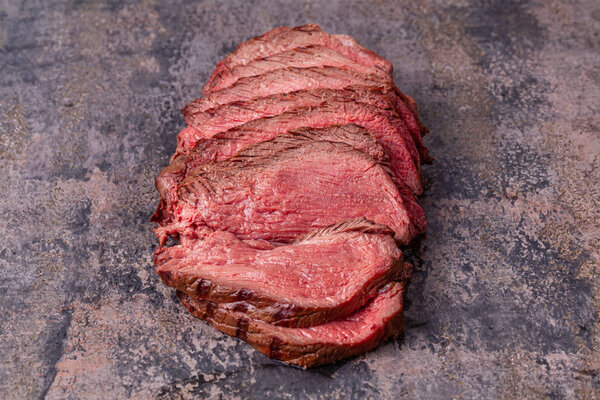 Roast beef slices on grey marble background