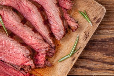 Biberiye ile ahşap kesme tahtası üzerinde rosto sığır eti yakın