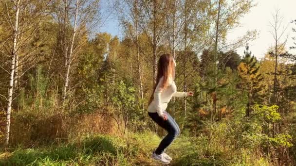 Vista lateral de la joven feliz salta y levanta una mano como un Superman — Vídeo de stock