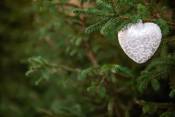 ハート、緑の木の背景のような形のクリスマスの装飾のおもちゃのクローズアップ — ストック写真