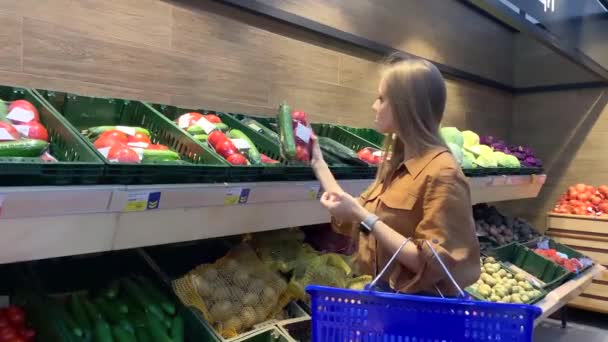 Jeune femme avec panier sélection de légumes frais dans une épicerie — Video