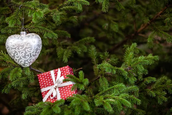圣诞树树枝之间的圣诞玩具和礼品盒。 新年背景 — 图库照片