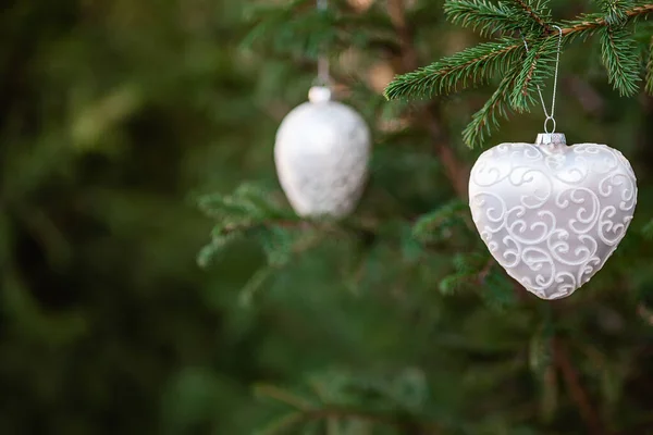 Christmas spruce decoration toys shaped like a heart hanging on a tree branch — Stock Photo, Image