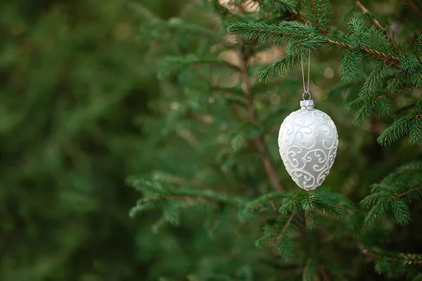 Juguete de decoración de Navidad colgado en rama de abeto con fondo de bosque verde —  Fotos de Stock