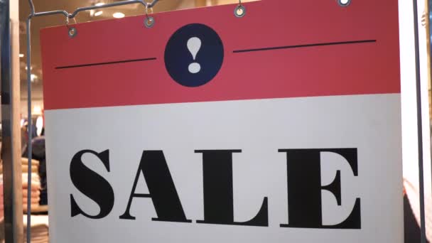 Sale sign in the shop window in shopping mall, discounts during seasonal sales — Stock Video