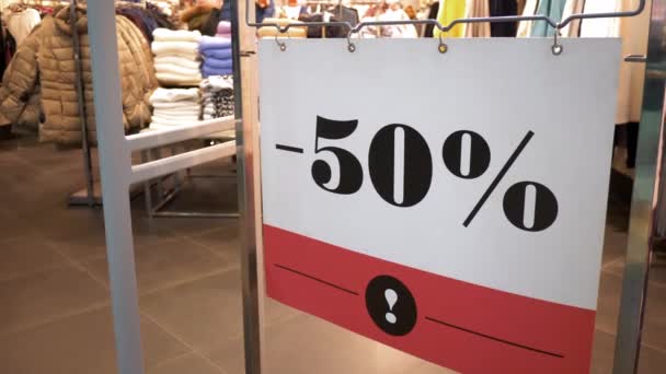 Sale sign -50 off in the clothing shop window in shopping mall, τεράστιες εκπτώσεις — Αρχείο Βίντεο