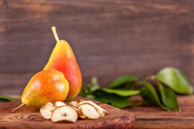 Ahşap arka planda ev yapımı kurutulmuş cips ve sağlıklı gıda kavramı olan taze armutlar.