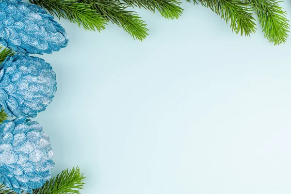 Glitter getextureerd speelgoed met kerstboom takken op blauwe papieren achtergrond — Stockfoto