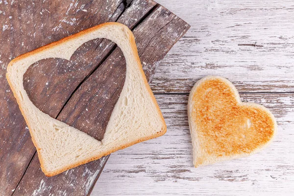 Pan tostado con el corazón cortado en la tabla de la vendimia, concepto feliz día de San Valentín — Foto de Stock