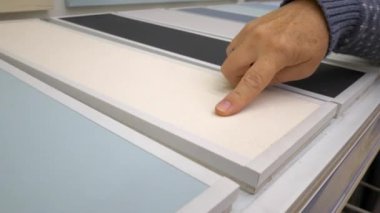 Diy AVM 'deki bir hırdavatçıda boya örneklerinin rengini seçen bir kadın.
