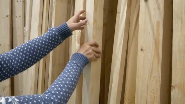 Vrouw handen kiezen een van hout planken in een hardware winkel in Diy winkelcentrum — Stockvideo