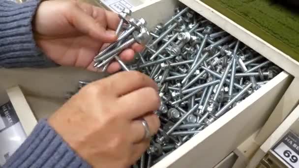 Woman hands choosing a metal fasteners in a hardware store in DIY shopping mall — Stock Video