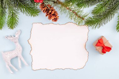 Noel süslemelerinde tebrik kartı. Kırmızı fiyonklu el yapımı hediye kutusu. Oyuncak geyik.