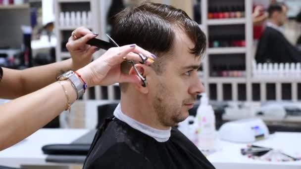 Muž Řezání vlasů rukama profesionálního kadeřníka v holičství — Stock video