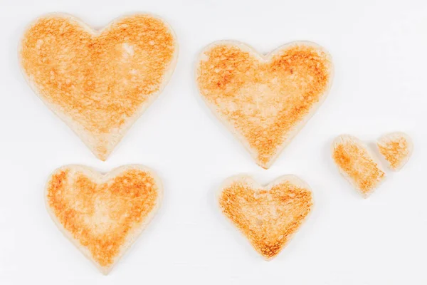 Group of toasted bread hearts with one broken heart together on white background — Stock Photo, Image