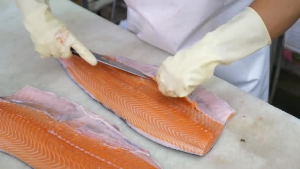 Крупный план резки и очистки рабочих рук большой нож для измельчения филе лосося — стоковое видео