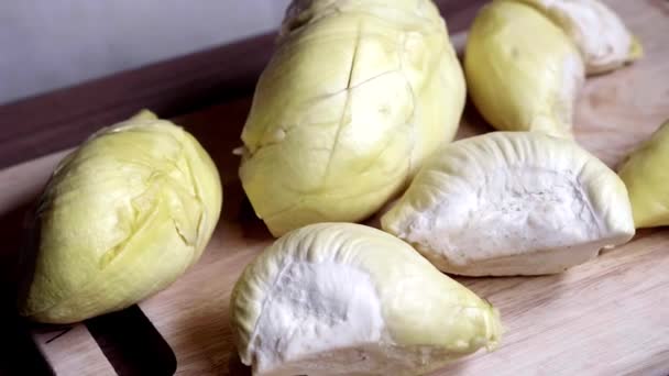Pedaços de Durian mentem em uma placa de madeira. Vista superior de fruta asiática doce e fedorenta — Vídeo de Stock