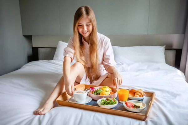 아늑 호텔 방에서 아침 식사를 하고 있는 젊은 아름다운 여인 — 스톡 사진