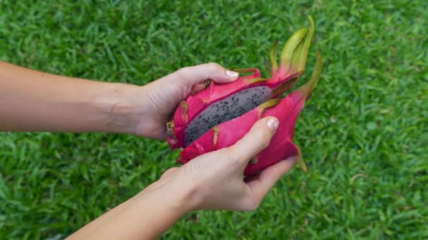 Gros plan de femmes mains ouvertes deux moitiés de fruits du dragon blanc frais Pitaya — Video