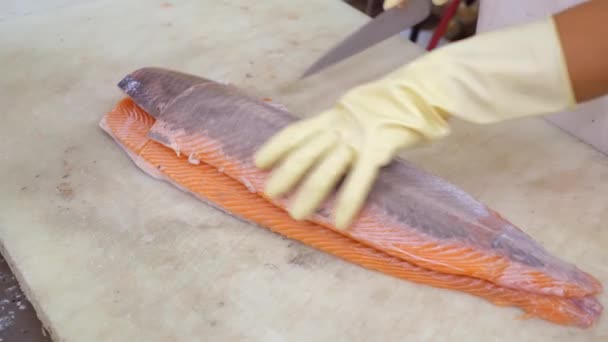 Close-up de mãos de trabalhador corte e limpeza filé de salmão grande faca de corte — Vídeo de Stock