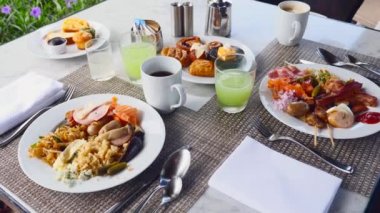Lüks Otel 'de kahvaltı. Tabaklar dolusu yemek, meyve suyu ve kahve.